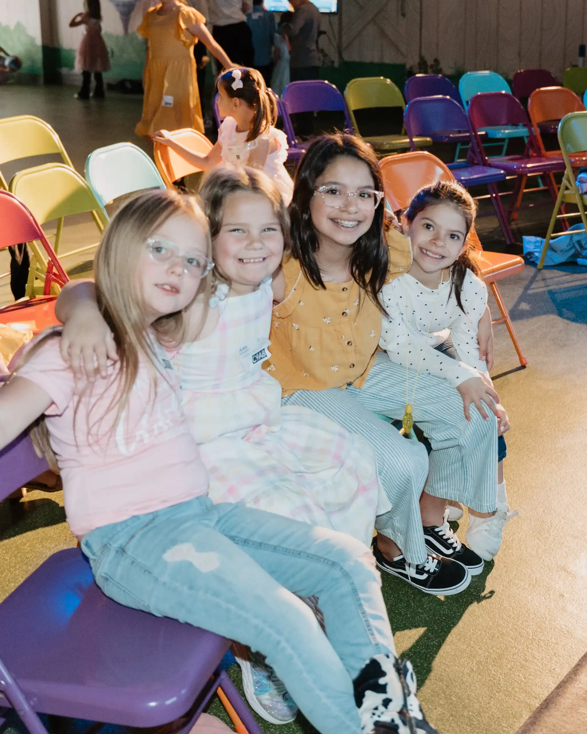 BC Kids leader sitting with four girls in colorful chairs