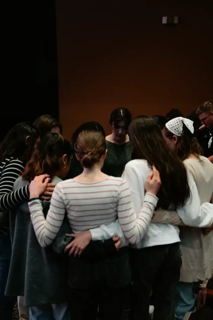 Group standing close together in a prayer circle