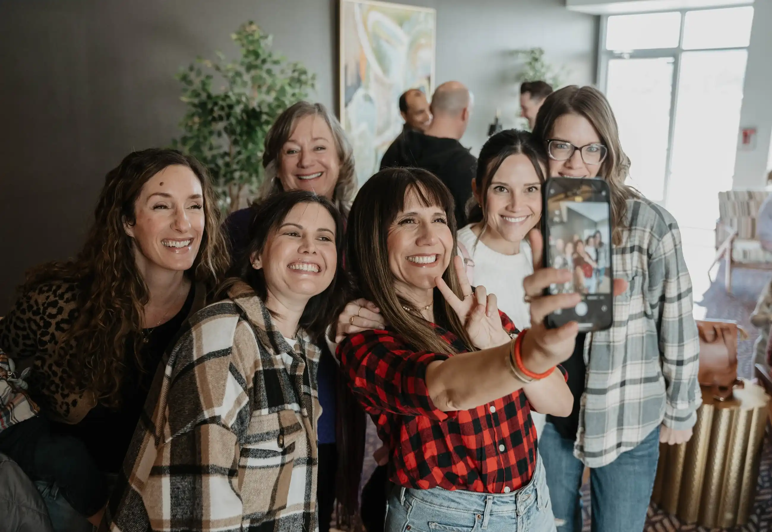 Women smiling together for a selfie at a Believer Church small group