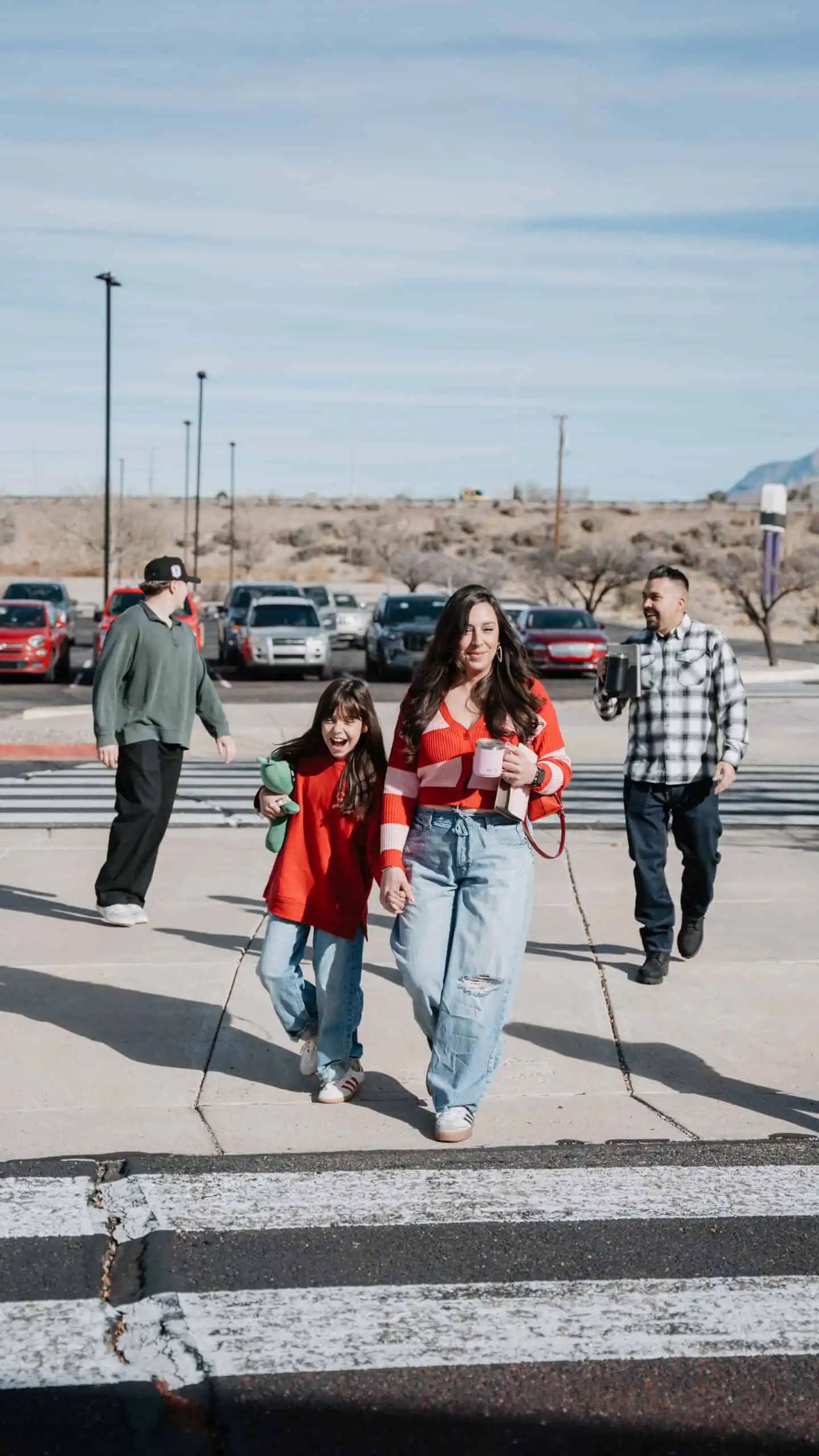 Family walking across a church parking lot crosswalk on a sunny day