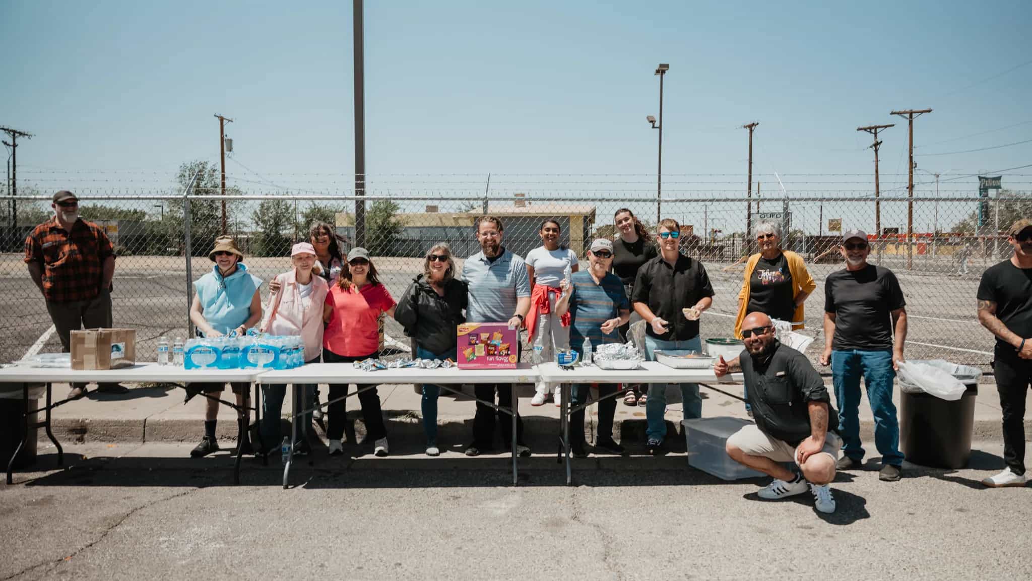 Love ABQ serve team gathered behind tables of food and water