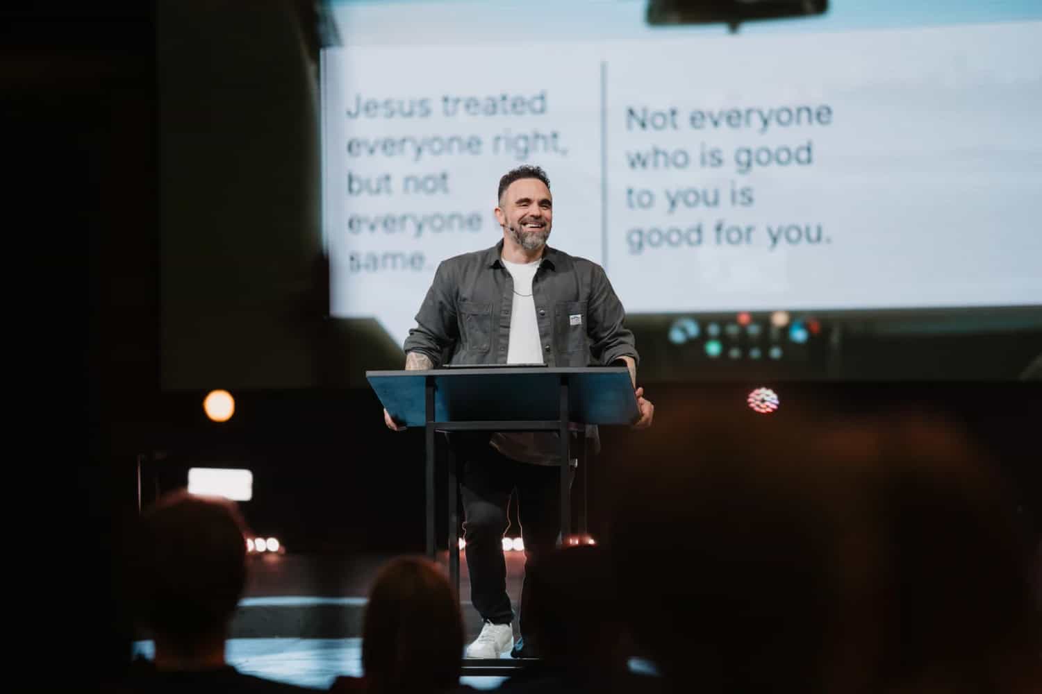 Pastor David Eiffert teaching on stage with the message slide behind him